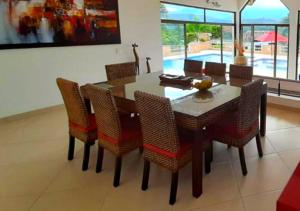 comedor con mesa y sillas en Bella Casa Campestre con Piscina Privada Anapoima, en Girardot