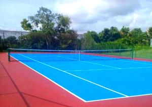 una pista de tenis de color azul y rojo en Bella Casa Campestre con Piscina Privada Anapoima, en Girardot