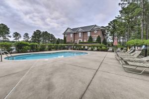 a swimming pool in front of a house with chairs at Anderson Creek Resort Condo on Golf Course with Pool in Spring Lake