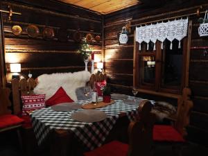 comedor con mesa, sillas y paredes de madera en Góralski dom niedaleko gondoli, en Szczyrk