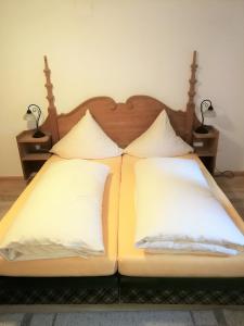 オーバーアマガウにあるCity Apartmentのベッド1台(白い枕2つ、ランプ2つ付)