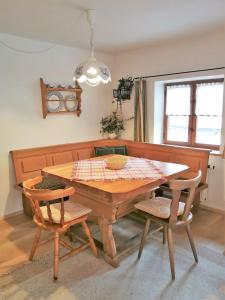 uma sala de jantar com uma mesa de madeira e cadeiras em City Apartment em Oberammergau
