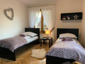 een slaapkamer met 2 bedden en een raam bij Apartament Góralka in Zakopane