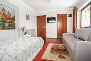 a white bedroom with a bed and a couch at Willa Jaś I Małgosia in Kościelisko