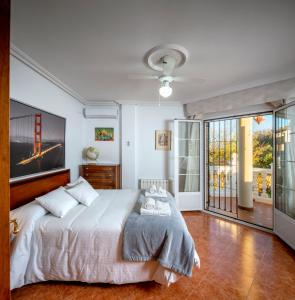 a bedroom with a bed and a large window at Vivienda Turística Rural Mari Carmen in Baeza