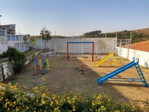un patio con un parque infantil colorido. en Pousada Canto dos Canários en Socorro
