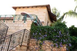 a building with a staircase with purple flowers at Erella's in Rosh Pinna