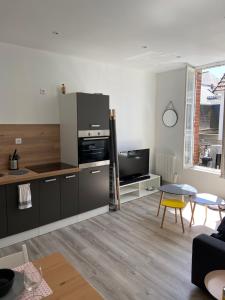 ein Wohnzimmer mit einer Küche und einem Tisch in der Unterkunft Cosy Flat Carteret - Appartement centre bourg - 4 personnes in Barneville-Carteret