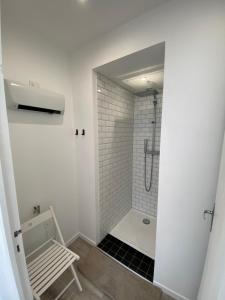 ein weißes Badezimmer mit Dusche und Sitzbank in der Unterkunft Cosy Flat Carteret - Appartement centre bourg - 4 personnes in Barneville-Carteret + 12 Fotos