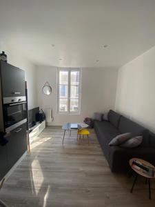 ein Wohnzimmer mit Sofa und Tisch in der Unterkunft Cosy Flat Carteret - Appartement centre bourg - 4 personnes in Barneville-Carteret