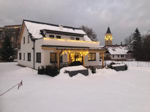 uma casa com luzes de Natal na neve em Zimmer/Wohnung Judenburg em Judenburg