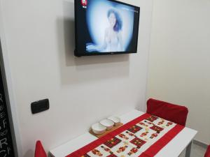 Zimmer mit einem Tisch und einem TV an der Wand in der Unterkunft Casetta SORIANO - Piazza Dante in Neapel