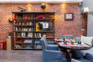 a brick wall with a table and chairs and a tv at Atelier Montparnasse Hôtel in Paris