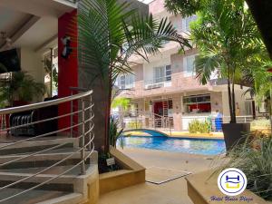 ein Pool mit Palmen und ein Gebäude in der Unterkunft Hotel Único Plaza in Villavicencio