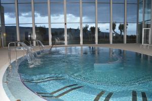a swimming pool with a fountain in a building at Hotel Balneario de Gravalos in Grávalos