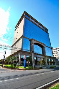 een groot glazen gebouw met een weg ervoor bij Comfort Suites São José do Rio Preto in Sao Jose do Rio Preto