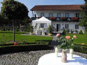 una casa blanca con una tienda blanca delante de ella en Gut Altholz Landhotel und Restaurant Hutter en Plattling