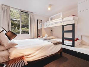 1 dormitorio con litera y escalera en Steamboat 2 bedroom with mountain view and central location en Thredbo