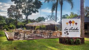 een groep tafels en stoelen met parasols bij Pirayu Hotel & Resort in Puerto Iguazú