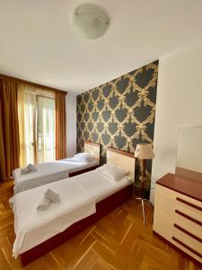 um quarto de hotel com duas camas e uma cómoda em Apartments First Line em Petrovac na Moru