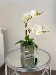 un jarrón con flores blancas sobre una mesa de cristal en Pensión MarViva, en Corcubión