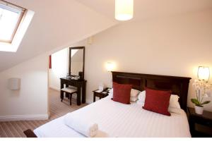 a bedroom with a large bed with red pillows at Park Central Hotel in Bournemouth