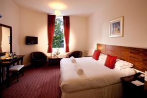 a hotel room with a large bed and a desk at Park Central Hotel in Bournemouth