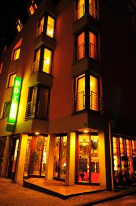 a tall building with lit up windows at night at Atelier Hotel Essen-City in Essen