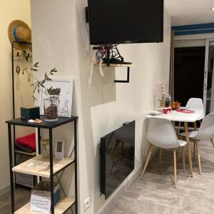 a living room with a table and a tv on a wall at Studio moderne Argeles sur mer.La plage à pieds, Espagne à 30mn in Argelès-sur-Mer