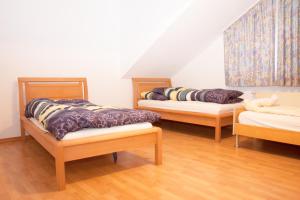 three beds in a room with wooden floors at Ferienwohnungen Beckingen in Beckingen