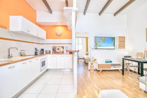 a kitchen and living room with white cabinets and a table at Foyal Suites in Fort-de-France