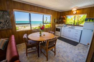 a kitchen with a table and a kitchen with a view of the ocean at Tidal Treasure - Collingwood Holiday Home in Collingwood
