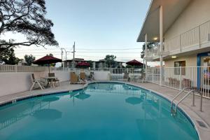 a pool at a hotel with chairs and tables at Motel 6-Monterey, CA in Monterey