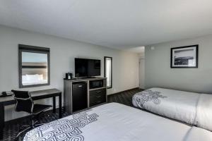 Voodi või voodid majutusasutuse Days Inn & Suites by Wyndham Spokane toas