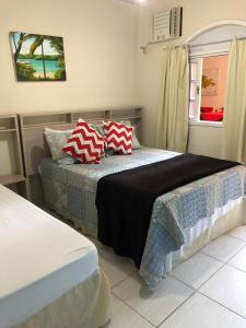 a bedroom with two beds and a window at Pousada Recanto da Ana Alice in Abraão