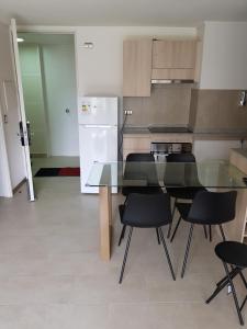 een keuken met een glazen tafel en zwarte stoelen bij Apartamento con jardin a pasos del mar La Serena in La Serena