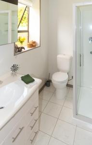 uma casa de banho branca com um WC e um lavatório em Guinea's Rest em Waipapa