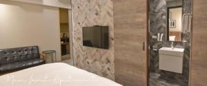 a bedroom with a bed and a tv on a wall at Morn forest apartment in Tainan