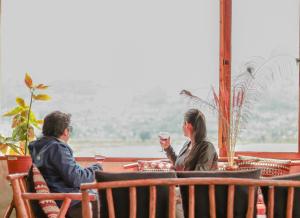 un hombre y una mujer sentados en una mesa con copas de vino en Hospedaje Vertientes del Imbabura, en Otavalo