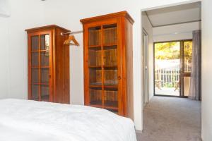 a bedroom with a bed and some glass cabinets at Guinea's Rest in Waipapa