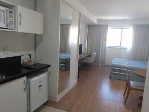 a room with a kitchen and a living room at Salvador Business & Flat propriedade in Salvador
