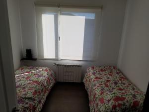 a small bedroom with two beds and a window at DEPARTAMENTO CALAFATE CENTRICO #3 in El Calafate
