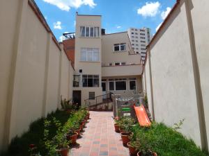 una pasarela de ladrillo con macetas delante de un edificio en Rendezvous Hostal, en La Paz