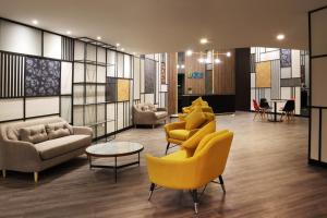 a lobby with couches and chairs and a table at ACES Hotel Kuala Lumpur in Kuala Lumpur