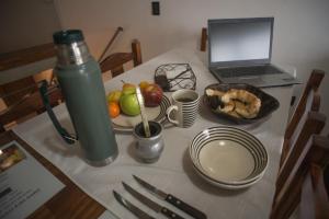 a table with a laptop computer and a bowl of fruit at Amares Apart - Departamentos 1 y 2 in Santa Clara del Mar