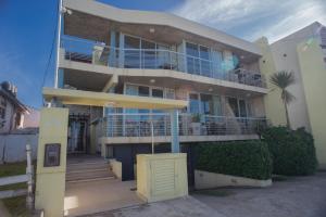 a large house with blue balconies on a street at Amares Apart - Departamentos 1 y 2 in Santa Clara del Mar