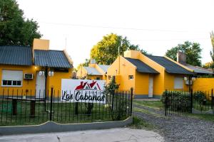 a yellow house with a sign on a fence at Las Cabañas in Colorado River