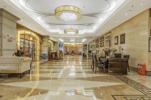 eine Lobby eines Gebäudes mit einem Tisch und Stühlen in der Unterkunft Haikou Jingheng Hotel - formerly the New Osrock Hotel in Haikou