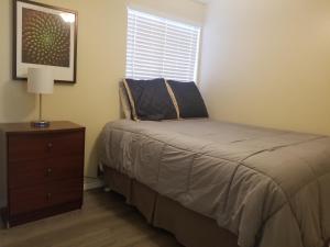 een slaapkamer met een bed, een dressoir en een raam bij Southwest Tucson Gateway in Tucson