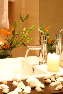 a bathroom sink with a faucet and a candle at Hotel Antonios in Olympia